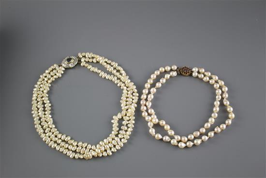 A double strand cultured baroque pearl necklace with yellow metal and garnet ? cluster clasp and one other simulated pearl necklace.